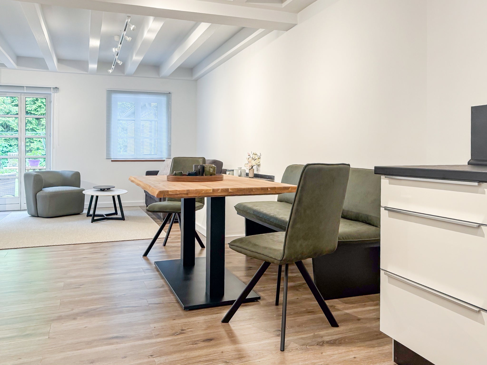 Ein großzügiger, offener Wohn- und Essbereich in einem der Art Apartments im Gutshaus am Rhein (Duisburger Landstraße 37, 40489 Düsseldorf). Diese Zimmer können von Reisenden gebucht werden und bieten den perfekten Rahmen für Ausstellungen von Künstlern der ARTSPACER Online-Galerie.