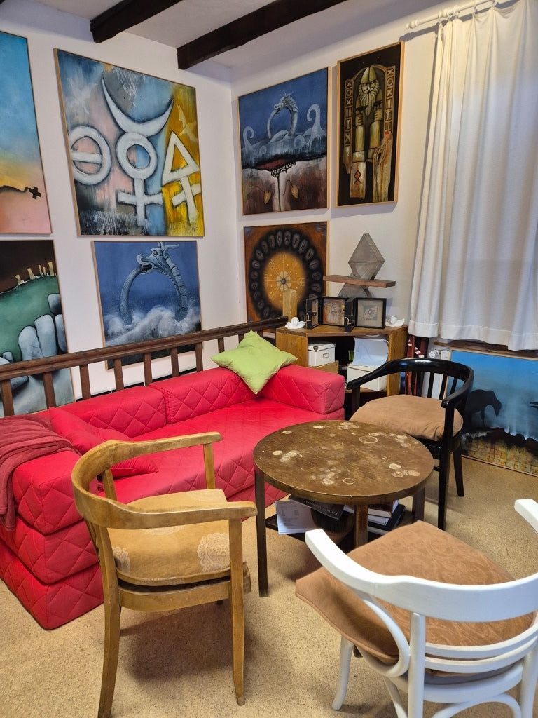 Kreative Atmosphäre im Atelier von Peter Jaschinski: Gemütliche Sitzecke für Sammler und Besucher, umgeben von mystischen und abstrakten Kunstwerken.
