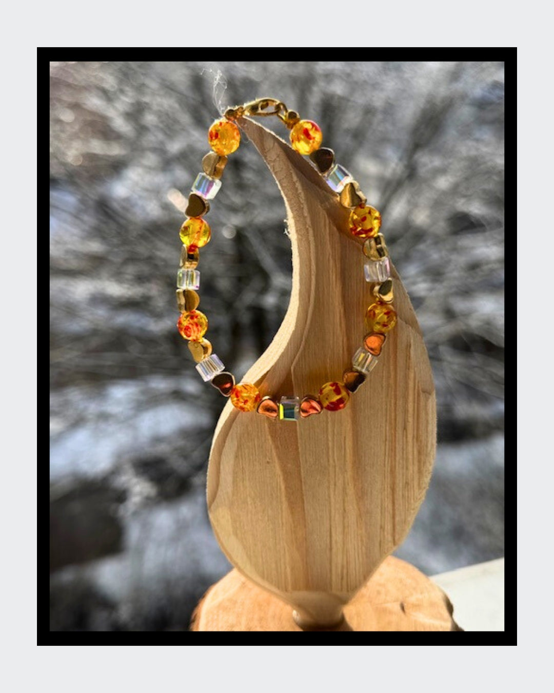 Edles Armband aus goldfarbenem Draht mit Karabinerverschluss. Marmorierter Bernstein, Swarovski Kristalle in Würfelform und vergoldete Herzen. 