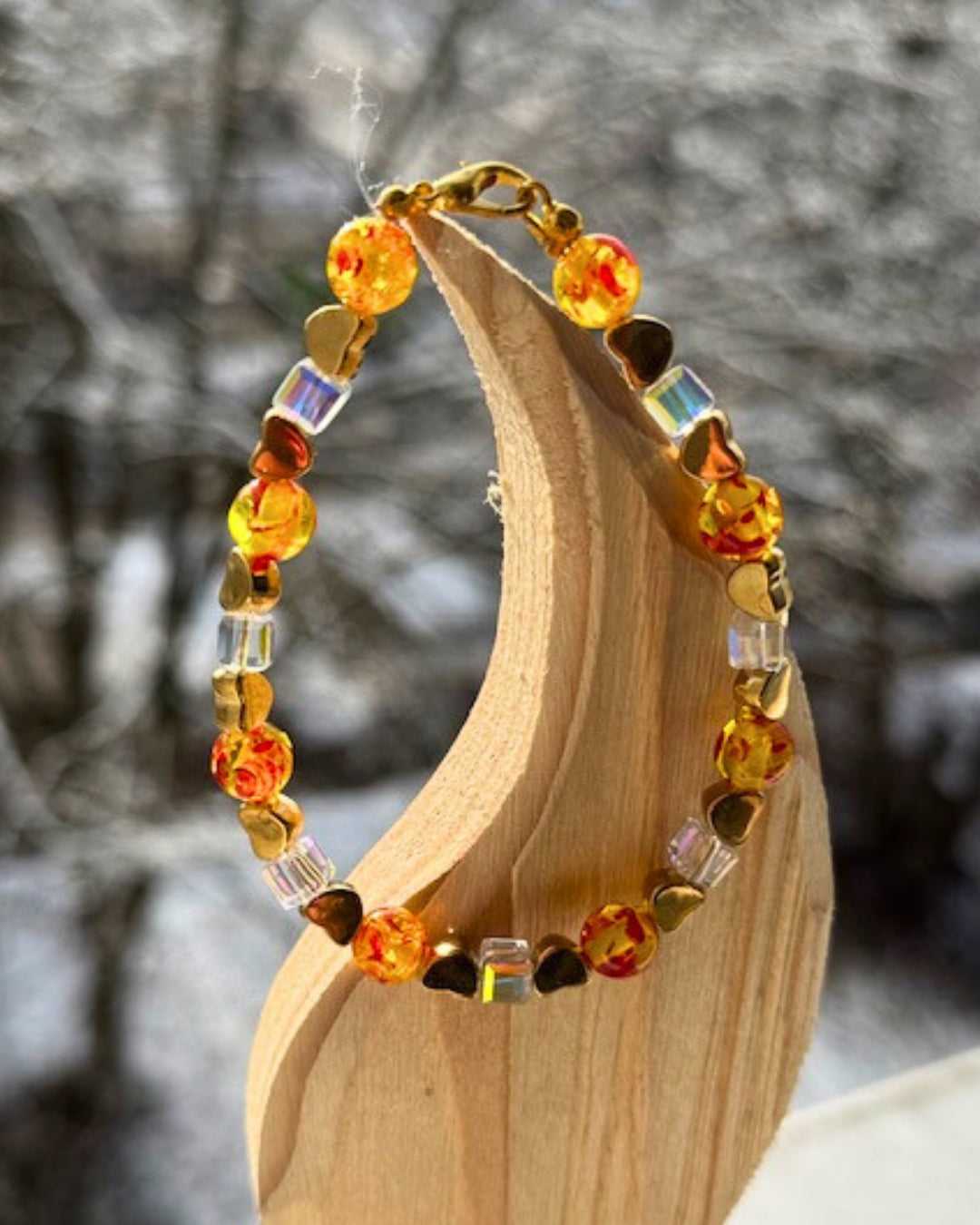Edles Armband aus goldfarbenem Draht mit Karabinerverschluss. Marmorierter Bernstein, Swarovski Kristalle in Würfelform und vergoldete Herzen. 