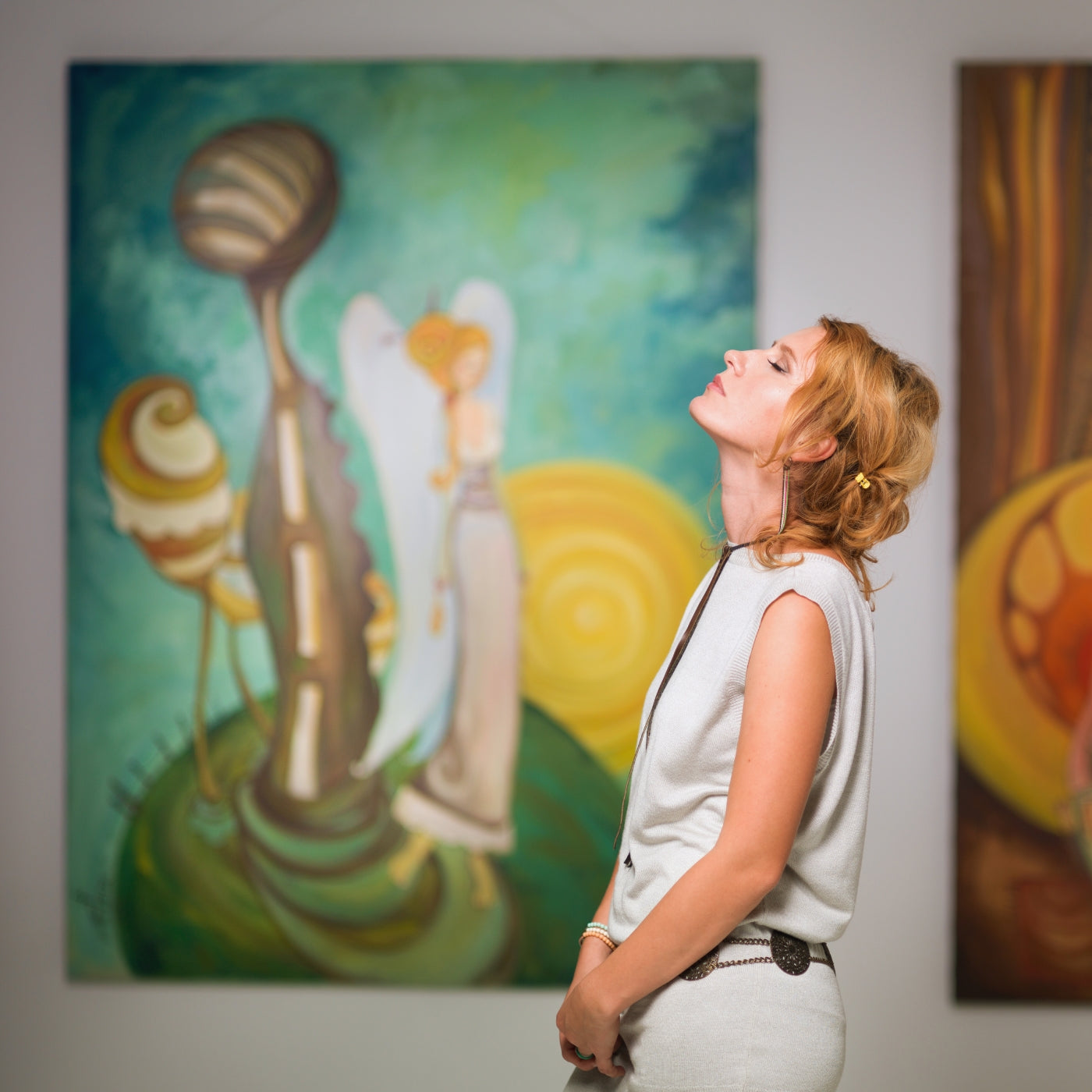 Abstraktes Gemälde mit länglichen Formen und warmen Erdtönen, ausgestellt in der ARTSPACER-Online-Galerie, bewundert von einer Frau im Vordergrund.