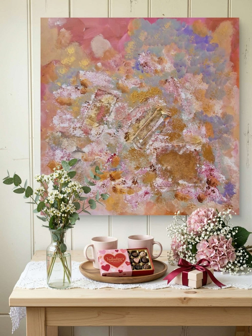 Abstraktes Mixed-Media-Werk „Erinnerungsgarten“ von BUCCODESIGN mit Jute, pastosen Blütenstrukturen und Farben in Rosa, Flieder, Apricot und Gold.