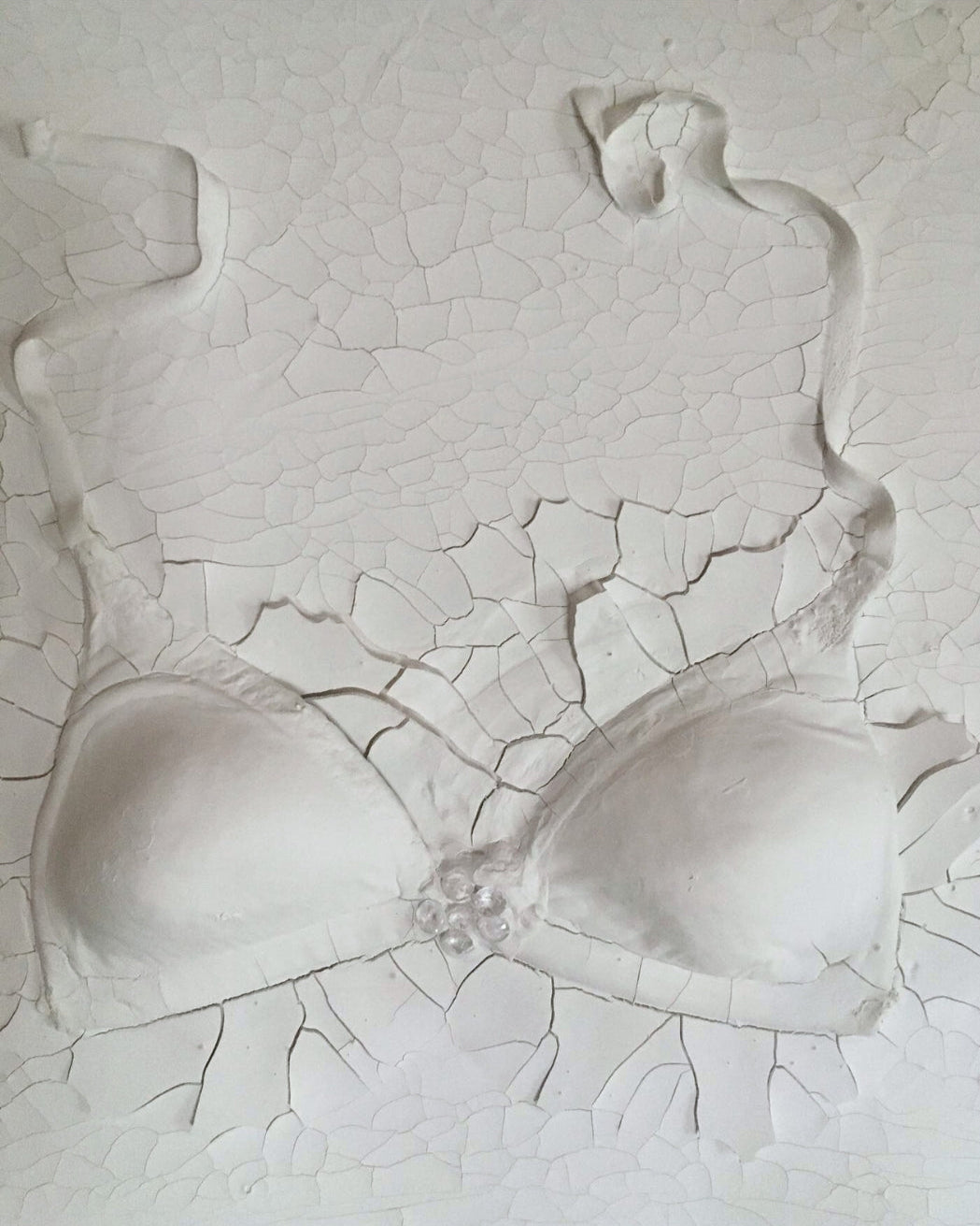 Gemälde "Verhüllte Wahrheit" von Federica, Textil auf Leinwand mit Acryl, 80x60 cm. Dreidimensionales Textilobjekt in Form eines Büstenhalters auf gerissener Leinwand in Weiß- und Grautönen. ARTSPACER