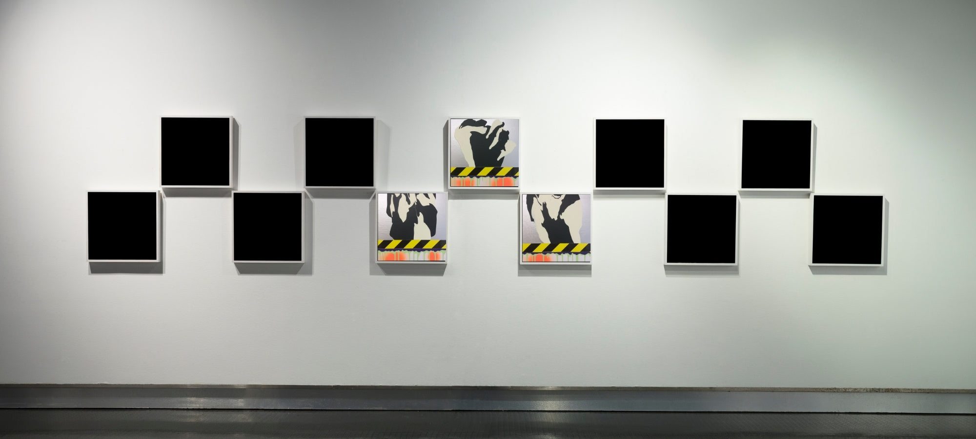 Jens Joneleit – PTG‑Serie: serielles Arrangement kleiner Leinwände in Zickzack‑Hängung; zentral zwei Mixed‑Media‑Werke mit schwarz‑gelbem Signalband und silhouettenartigen Formkörpern | ARTSPACER