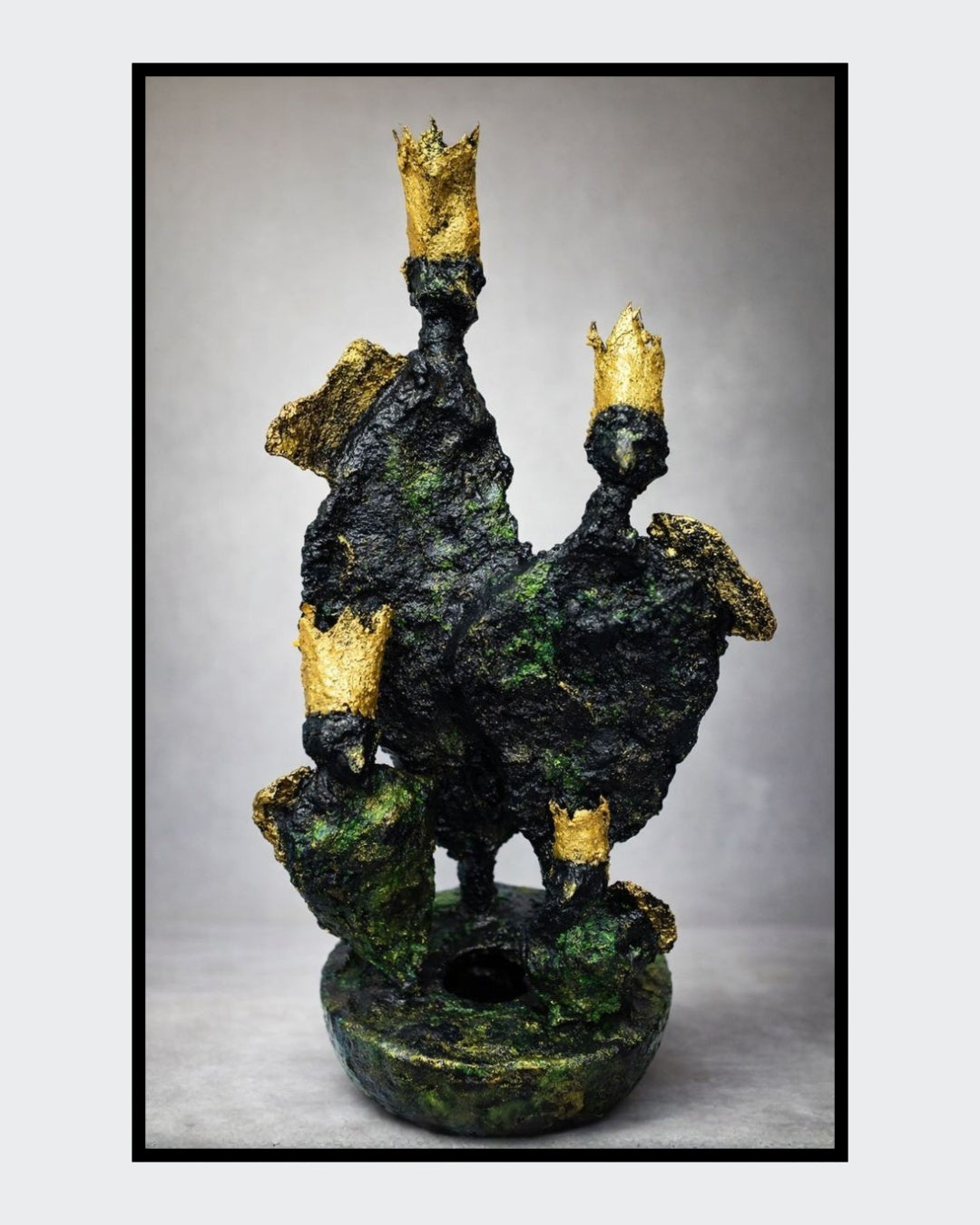 Eine abstrakte Skulptur von Heidi Minetti aus dunklem Faserbeton mit grünen Nuancen. Mehrere aufragende, organische Formen sind mit kleinen goldenen Kronen oder Spitzen versehen und stehen auf einer runden Basis.