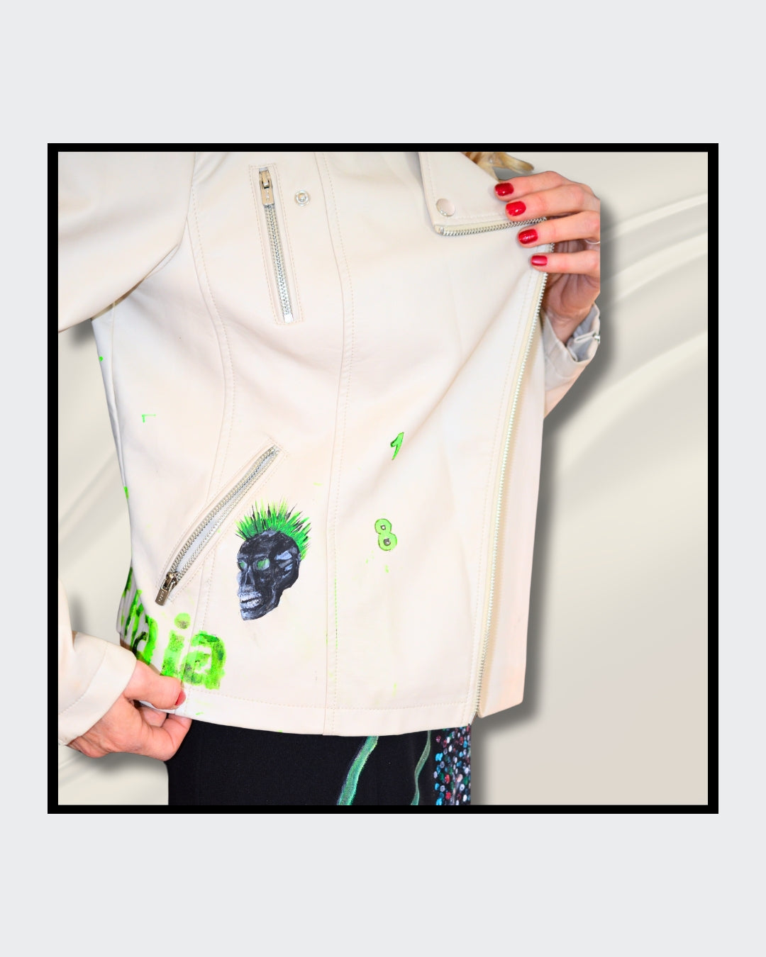 Fashionart von Kaja Schäfer: Eine Person trägt eine handbemalte weiße Bikerjacke mit grünem Totenkopf-Motiv. Dieses Kunstwerk vereint mutige Farben und einzigartigen Stil.
