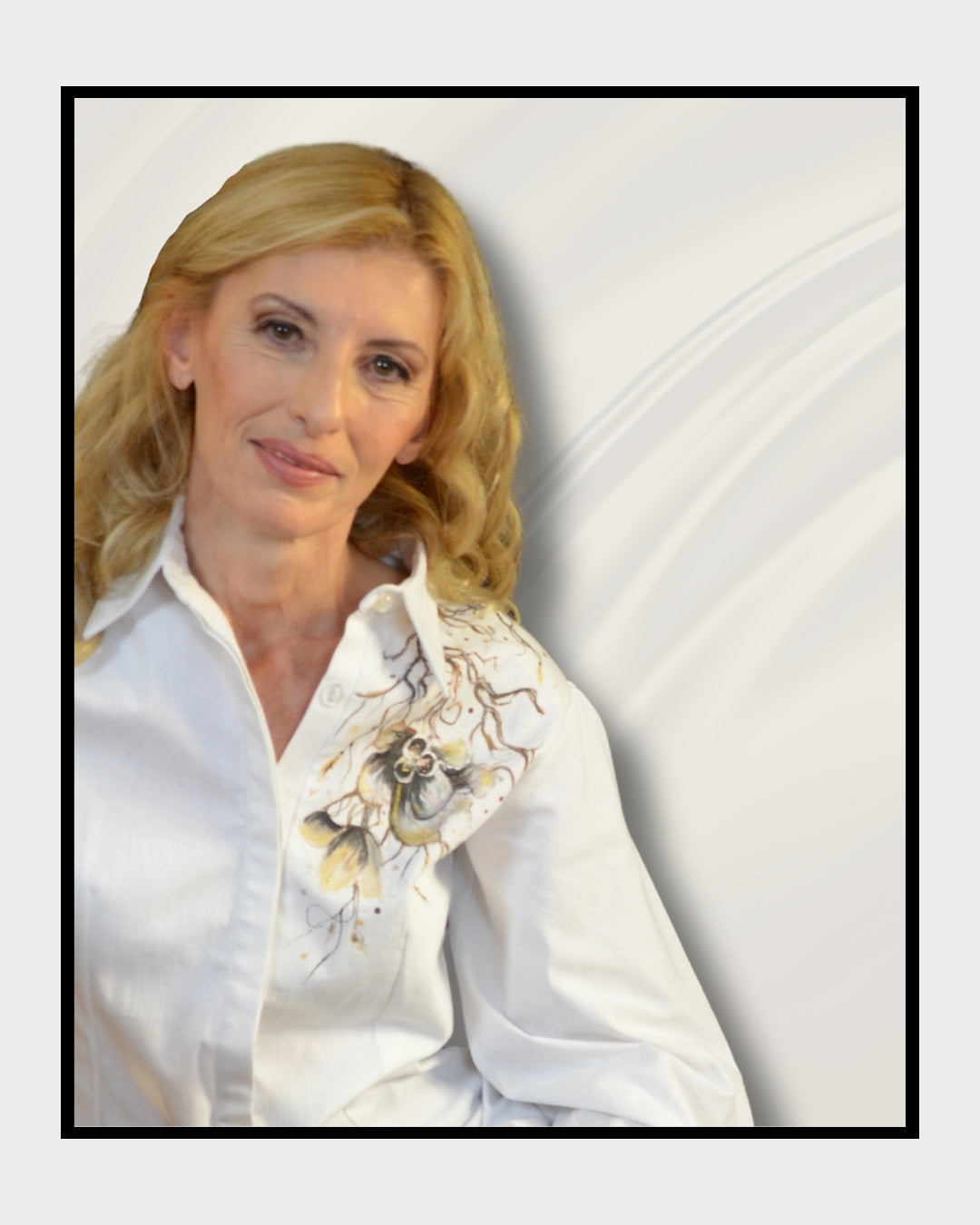 Fashionart von Kaja Schäfer für ARTSPACER: Nahaufnahme einer Frau. Weiße Seidenbluse mit floralem Motiv, blonde wellige Haare, goldener Armreif und roter Nagellack. Cremiger Hintergrund mit fließenden Stoffen.