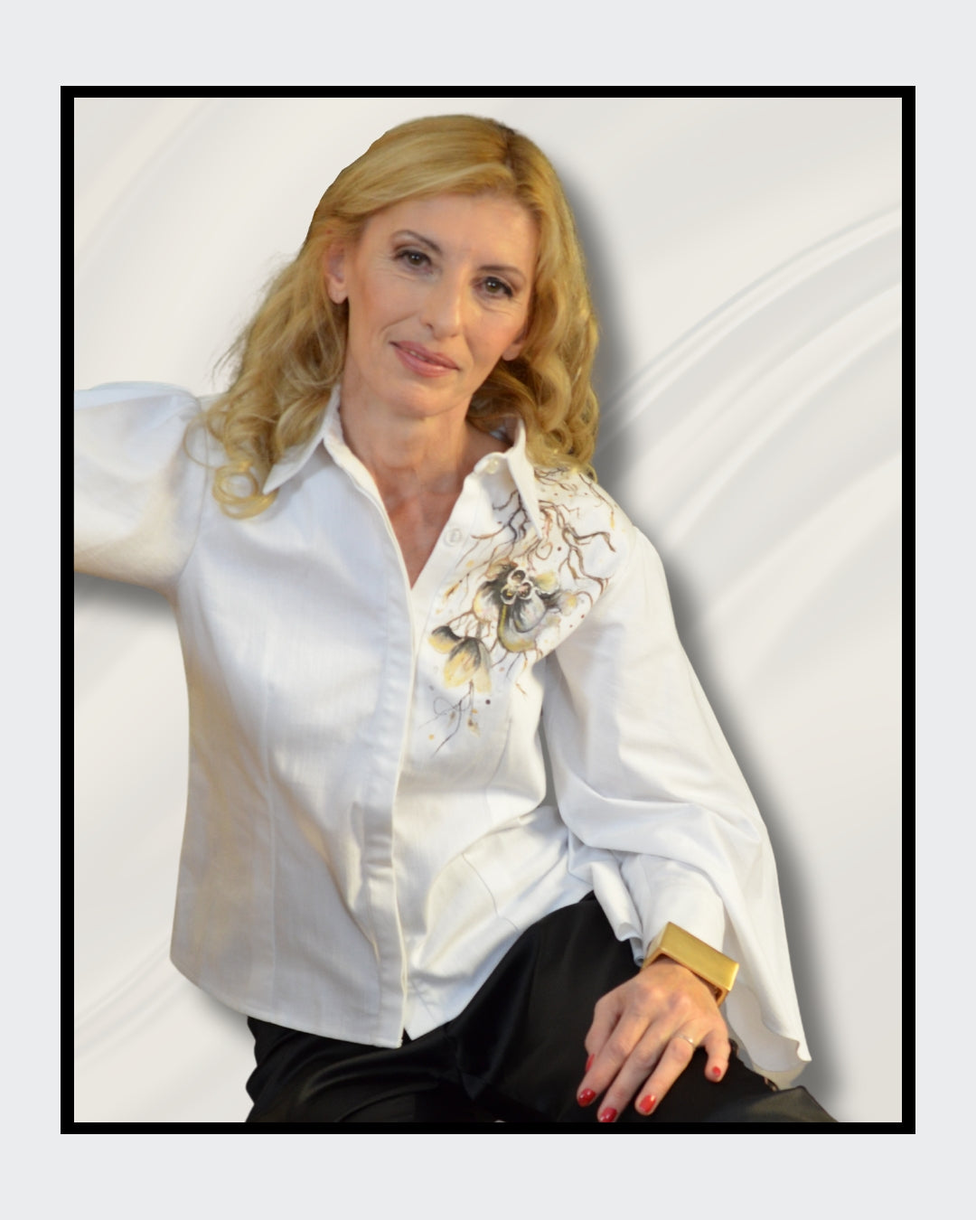 Fashionart von Kaja Schäfer für ARTSPACER: Nahaufnahme der Frau. Weiße Seidenbluse mit floralem Motiv, blonde wellige Haare, goldener Armreif und roter Nagellack. Cremiger Hintergrund mit fließenden Stoffen.