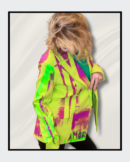 Fashionart von Kaja Schäfer: Eine Person trägt eine leuchtend bunte Neonjacke mit abstrakten Designs Das Gesicht ist verdeckt. Dieses Kunstwerk betont mutige Farben und einzigartigen Stil.