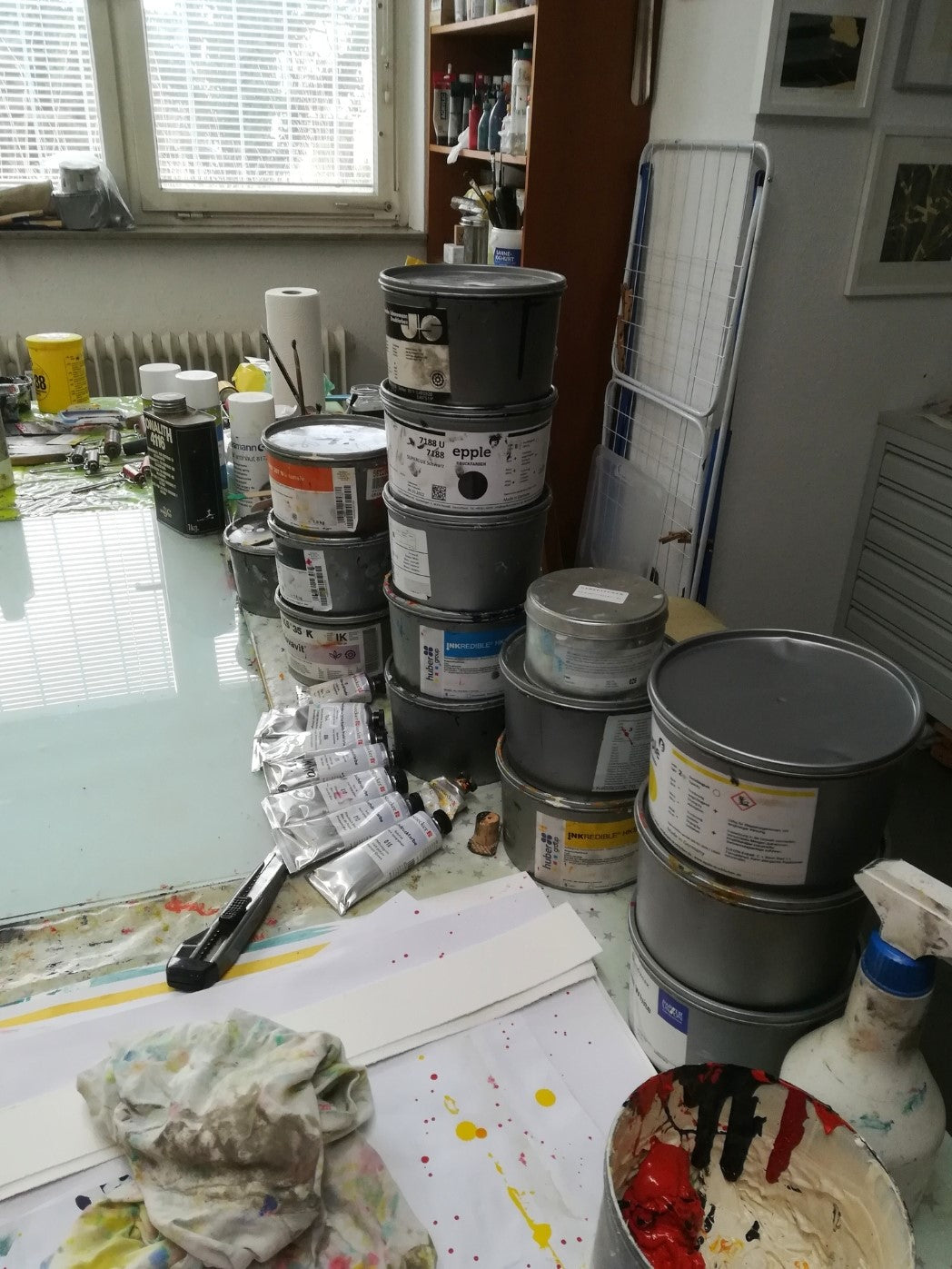 Blick ins Atelier von Marlis G Schill, Tisch mit Farbeimern, Tuben und Pinseln