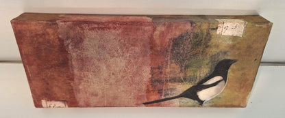 Collage „Elster“ von Monika Schiwy-Jessen, Querformat auf Box, handgefärbte Papiere und Stoffe, Naturmotiv, 10x24,5x2,5 cm.
