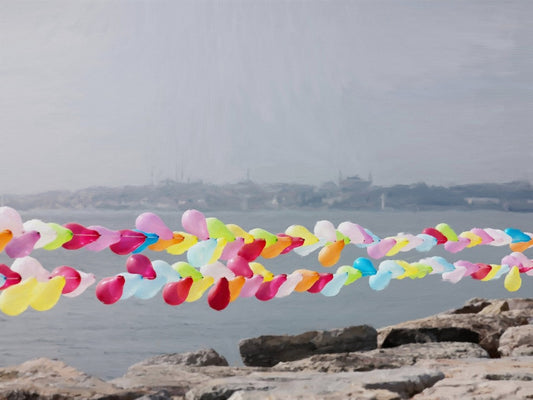 Das fotorealistische Digitalgemälde "Hagia Sofia mit Vordergrund" von nostrokesbitte zeigt die Istanbuler Skyline mit der Hagia Sofia im Hintergrund. Im Vordergrund spannen sich bunte Luftballonketten über das graue Meer. Das Werk ist auf Leinwand gedruckt und in limitierter Auflage bei ARTSPACER erhältlich.