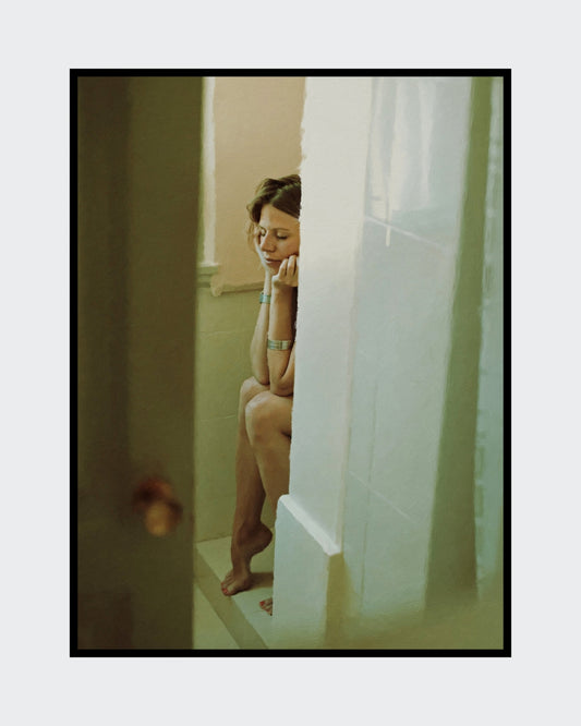 Das Kunstwerk "Im Fluss des Alltäglichen" des Künstlers nostrokesbitte ist ein fotorealistisches, digitales Gemälde. Das Hochformat zeigt eine Frau, die, mit nach unten gesenktem Kopf, auf einem Duschrand sitzt. Ihre Augen sind geschlossen, die Arme verschränkt und die Hände stützen das Gesicht. Die Farbtöne sind warm und gedämpft. Das Bild, das einen intimen Moment der Ruhe darstellt, wurde auf Leinwand gedruckt und ist in limitierter Auflage in der Online-Galerie ARTSPACER erhältlich.