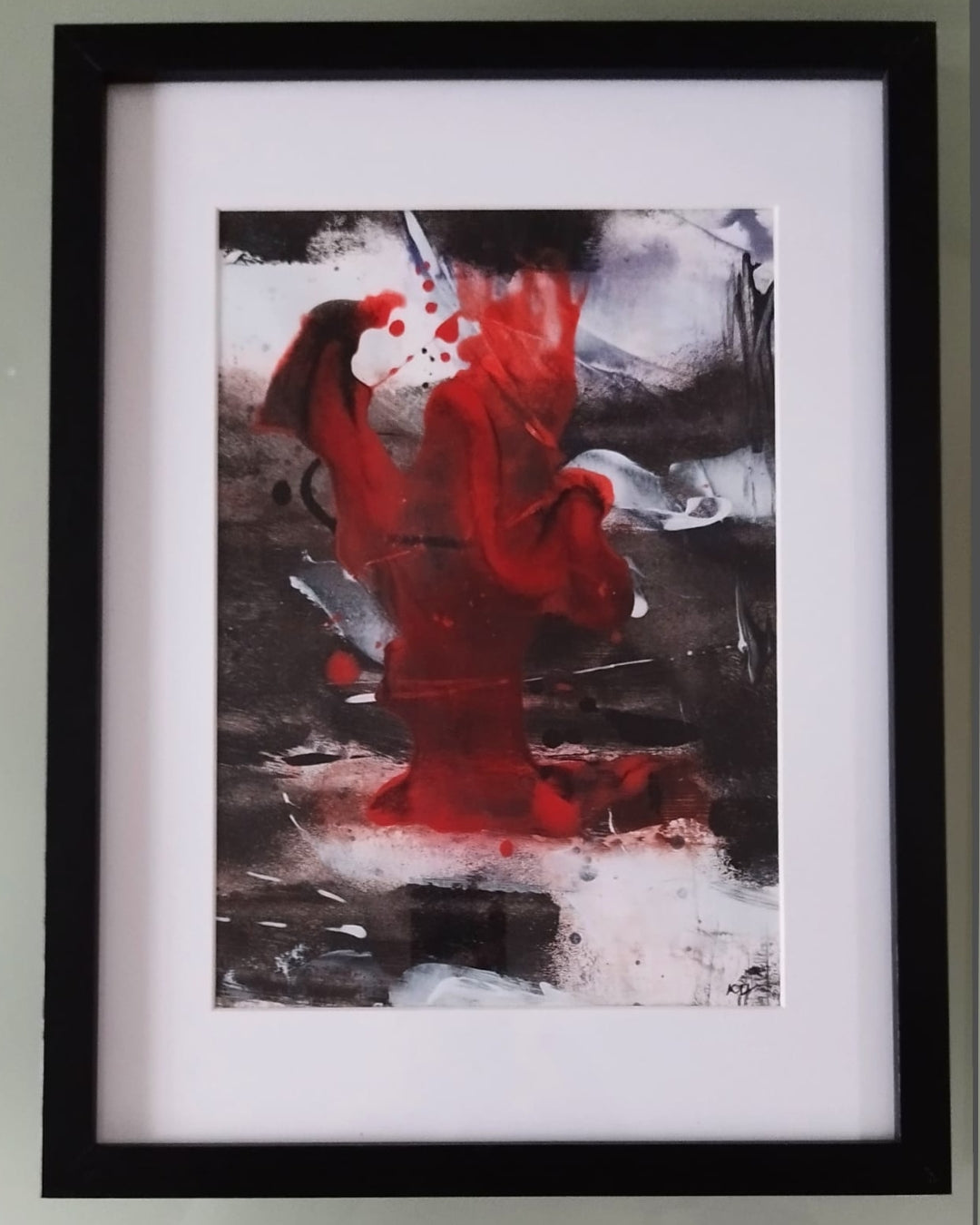 Gerahmte abstrakte Mischtechnik „Stille Kontraste 01“ von Olga Kühn auf Papier mit kraftvollem rotem Zentrum, schwarzen, weißen und braunen Flächen sowie weißem Passepartout.