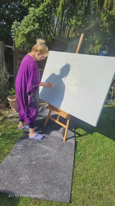 Video: Petra Erengil im Garten beim Malen vor einer Staffelei mit Leinwand.