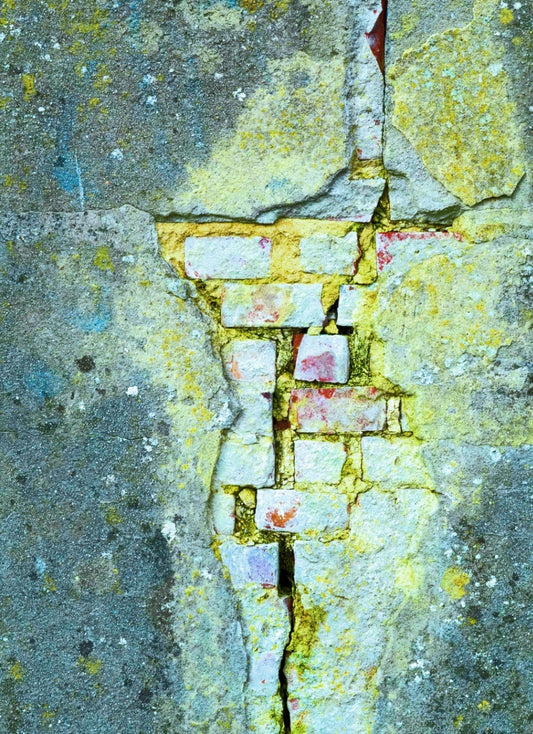 Digitale Fotografie "Alles ist vergänglich" von Ralf Sempf auf Leinwand mit Keilrahmen, 80x60 cm. Das Werk zeigt eine Nahaufnahme einer alten, verwitterten Wand mit einem langen Riss. Die Farbgebung in Türkis-, Gelb- und Grüntönen verstärkt den Eindruck von Verfall und Zerbrechlichkeit. 