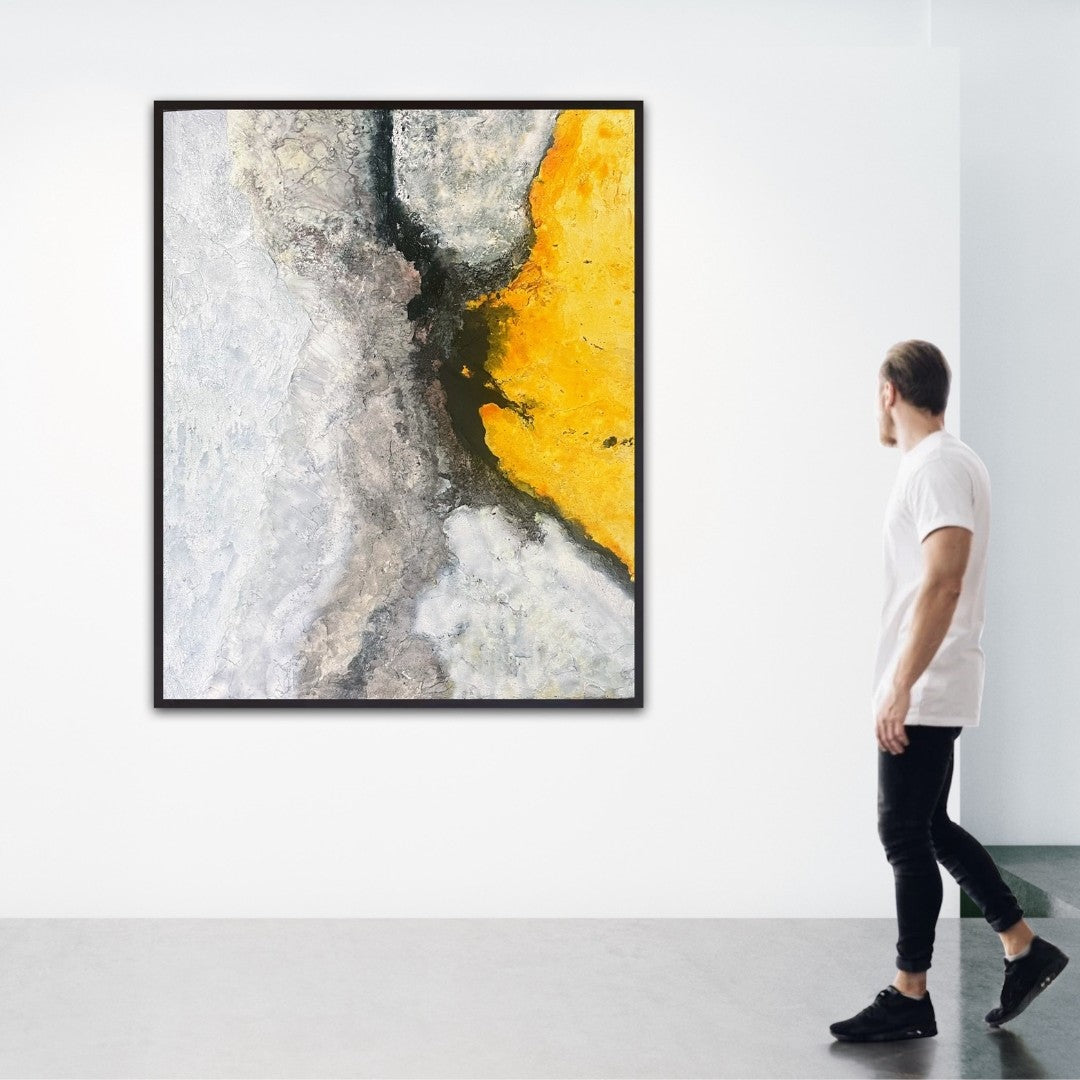 Das abstrakte Gemälde "Zwischenraum" von Sigrid Bautze-Klinder zeigt eine vertikale Komposition. Die linke Bildhälfte ist in hellen, kalten und monochromen Grautönen gehalten, die wie eine strukturierte, gefrorene Oberfläche wirken. Die rechte Hälfte wird von einem leuchtenden, kräftigen Gelb dominiert. In der Mitte der beiden Flächen befindet sich ein dunkler, fast schwarzer Spalt, der die gegensätzlichen Farben voneinander trennt und verbindet. Das Werk ist ungerahmt und mit verschiedenen Materialien wie 