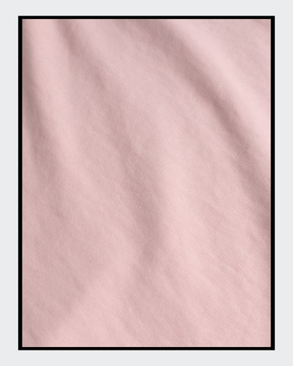 Stoffdetail von: Ein kurz geschnittener, rosafarbener Hoodie mit überschnittenen Schultern. Extralange Bündchen mit Daumenloch und eine bedruckte Kunstgrafik auf der Vorderseite. Mode von Soulfashion Lyrikherz & Springer, erhältlich bei FEMARTSPACE.