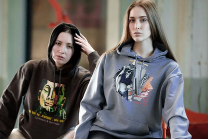 Models, die Unisex-Hoodies tragen mit Kängurutasche und Kapuze. Auf der Vorderseite ist ein Kunstwerk gedruckt. 
