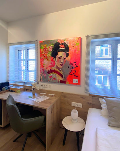 Porträt "Geisha" von Susann Versteegen (ARTSPACER). Eine Frau mit traditioneller Frisur vor einem leuchtenden, neon-pinken und grau-grünen, abstrakten Hintergrund, akzentuiert durch ein schwarzes Kanji-Schriftzeichen. Ausgestellt im Gutshaus am Rhein, Düsseldorf.
