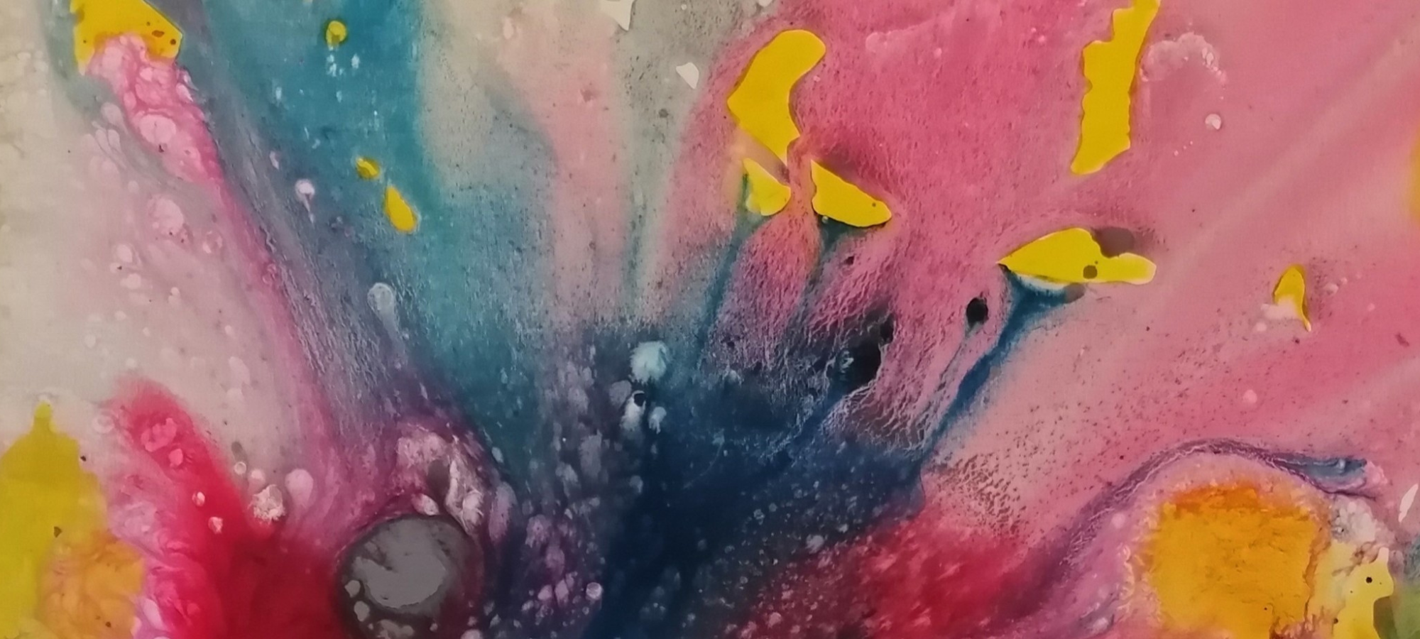 Ein abstraktes, fließendes Kunstwerk von Susanne Schwartinsky-Probst mit organischen Formen in leuchtenden Farben. Von einem dunklen, blau-violetten Zentrum gehen strahlenförmig weiche Verläufe in Pink, Magenta und hellem Blau aus. Markante, leuchtend gelbe Farbtupfer setzen kräftige Kontraste auf der ansonsten sanft ineinander verlaufenden, fast aquarellartigen Oberfläche. Die Struktur erinnert an flüssige Tinte oder eine mikroskopische Aufnahme von Farbpigmenten.