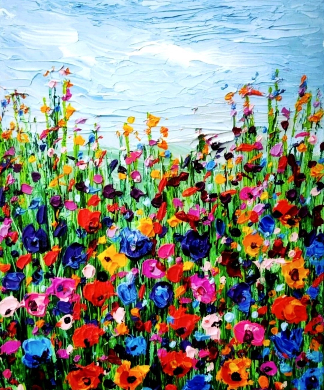 Ein farbenfrohes Gemälde zeigt eine Wiese voller wilder Blumen, die bis zum Horizont reicht. Der Himmel ist blau und wolkenlos. Die Blumen sind in verschiedenen Farben gemalt, darunter Rot, Pink, Blau und Gelb. Die dicke Farbschicht vermittelt eine lebendige und haptische Textur. Kunstwerk von Susanne Stepbach aus Wuppertal.