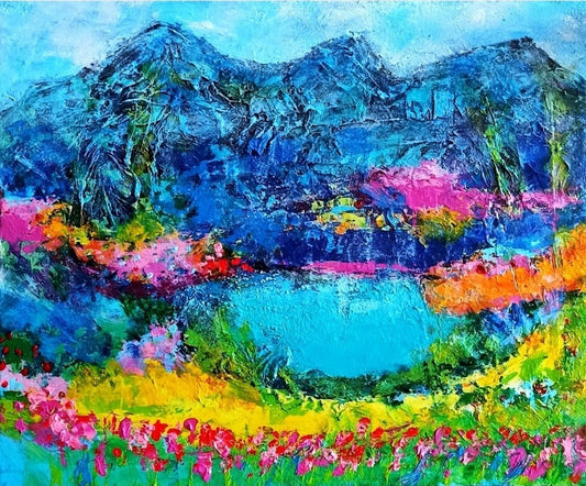 Ein abstraktes Gemälde zeigt eine Landschaft mit Bergen und einem See. Die Berge sind in kräftigem Blau gehalten, während der See in einem leuchtenden Türkis schimmert. Im Vordergrund blüht eine Wiese in bunten Farben. Die dicken Farbschichten und die verschiedenen Materialien, wie Sand und Seidenpapier, verleihen dem Bild eine besondere Struktur und Tiefe. Kunstwerk von Susanne Stepbach, Wuppertal.